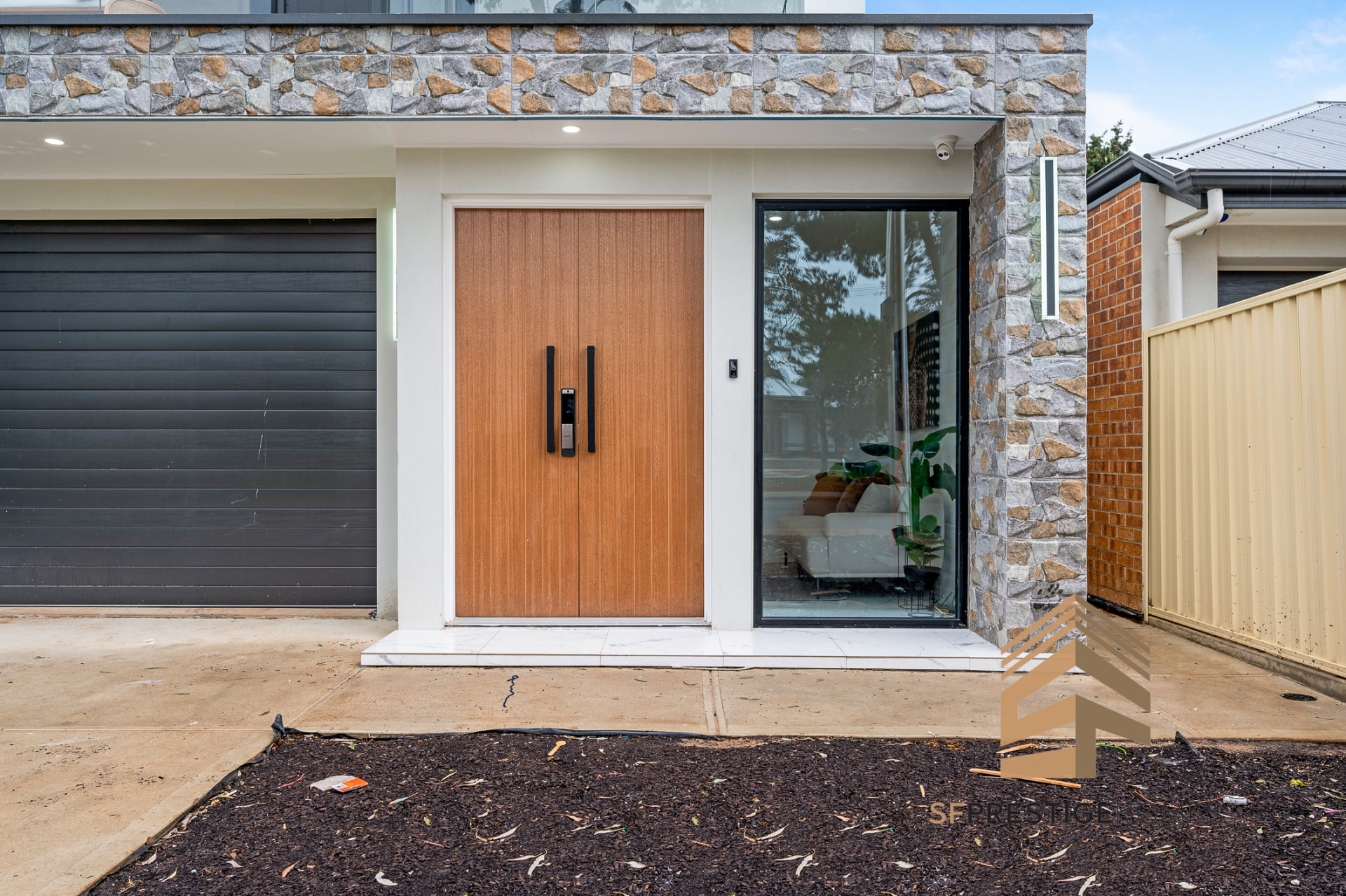 Entry of an SF Prestige home with timber door and natural stone cladding